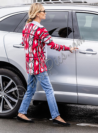 Kate Moss with loose hair knot, wearing denims, multi coloured top and ballet pumps