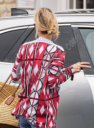 Kate Moss with loose hair knot, wearing denims, multi coloured top and ballet pumps