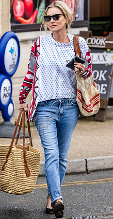 Kate Moss with loose hair knot, wearing denims, multi coloured top and ballet pumps