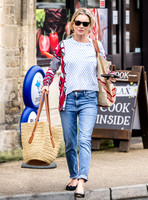 Kate Moss with loose hair knot, wearing denims, multi coloured top and ballet pumps