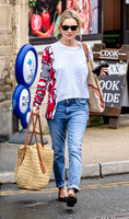 Kate Moss with loose hair knot, wearing denims, multi coloured top and ballet pumps