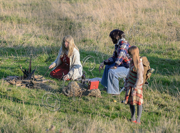 Unknown group of characters on set in field by campfire