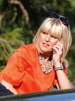 Close up of Asley Jensen in character of Agatha Raisin wearing bright orange