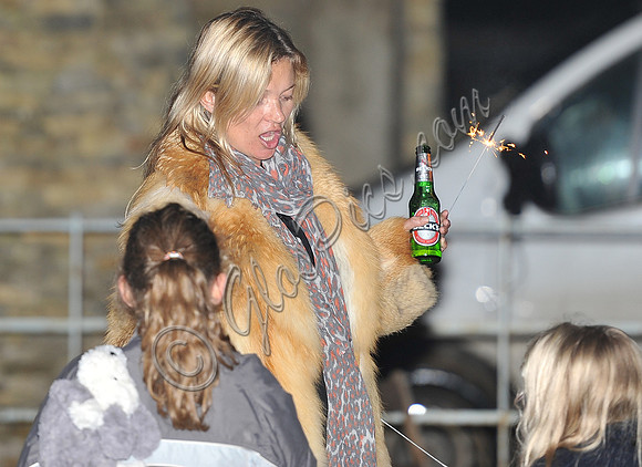 Kate Moss celebrates Guy Fawkes, with a bottle of Beck's beer and a sparkler