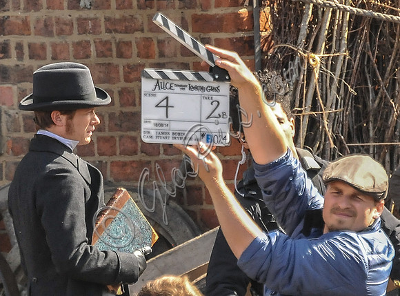 Ed Speleers side shot with a male wearing a flat cap holding up a clapperboard