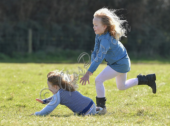 Mia Tindall and Savannah Phillips playing in the grass