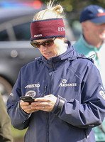 Zara Tindall texting wearing Musto headband and jacket