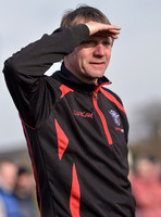 Stuart 'Psycho' Pearce for Longford AFC wearing team tracksuit watching game with eyes shielded from the sun, waist up.