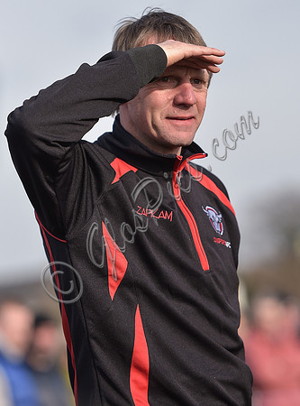 Stuart 'Psycho' Pearce for Longford AFC wearing team tracksuit watching game with eyes shielded from the sun, waist up.