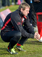 Stuart 'Psycho' Pearce for Longford AFC wearing team tracksuit, crouched down, hands clasped together, contemolation.