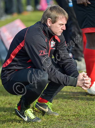 Stuart 'Psycho' Pearce for Longford AFC wearing team tracksuit, crouched down, hands clasped together, contemolation.