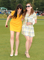 Treading divots at polo match, Lilah Parsons wearing bright yellow mini dress with another female