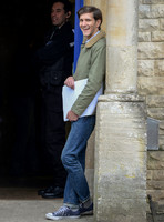 Mathew Baynton leaning against wall, smiling, police officer in background
