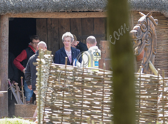 Peter Capaldi and crew members on the Doctor Who set. Also in shot a basket filled with swords, and a large wooden horse,