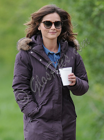 Jenna Coleman on 29th birthday, on set to film Doctor Who, wearing sunglasses and padded purple coat holding polystyrene cup