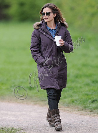 Full length shot of Jenna Coleman on 29th birthday, on set to film Doctor Who, wearing sunglasses and padded purple coat holding polystyrene cup