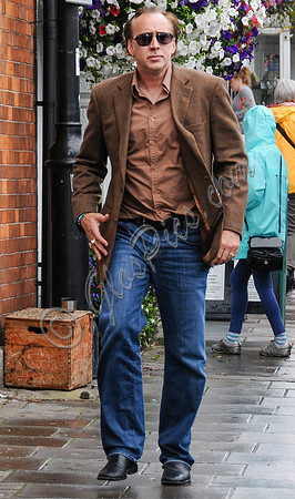 Nicolas Cage wandering around Glastonbury in the rain