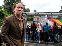 Nicolas Cage wandering around Glastonbury in the rain