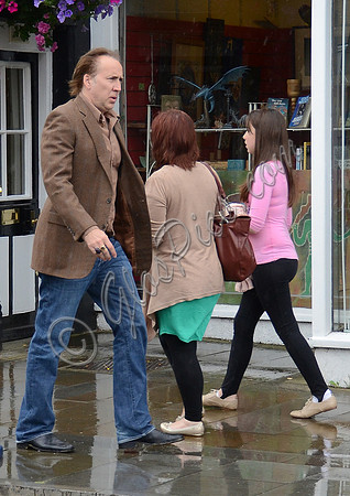Nicolas Cage wandering around Glastonbury in the rain