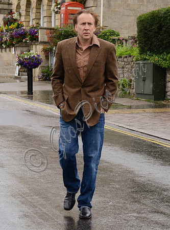 Nicolas Cage wandering around Glastonbury in the rain
