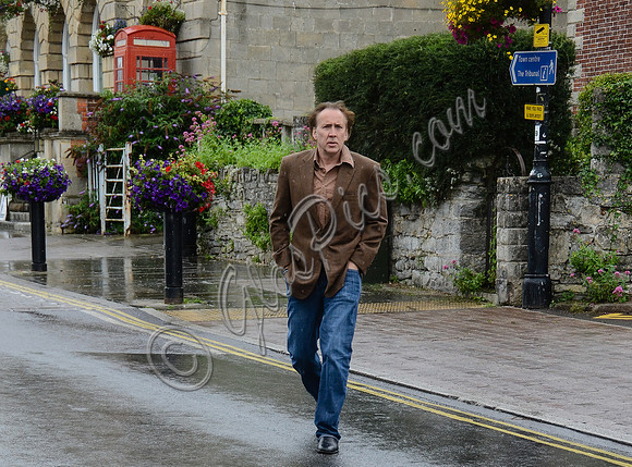 Nicolas Cage wandering around Glastonbury in the rain
