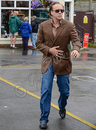 Nicolas Cage wandering around Glastonbury in the rain