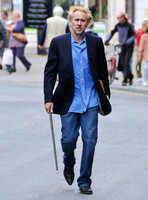 Blonde and bearded, Nicolas Cage with silver tipped walking cane