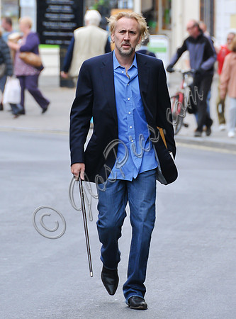 Blonde and bearded, Nicolas Cage with silver tipped walking cane