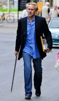 Blonde and bearded, Nicolas Cage with silver tipped walking cane