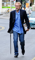 Blonde and bearded, Nicolas Cage with silver tipped walking cane