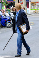 Blonde and bearded, Nicolas Cage with silver tipped walking cane