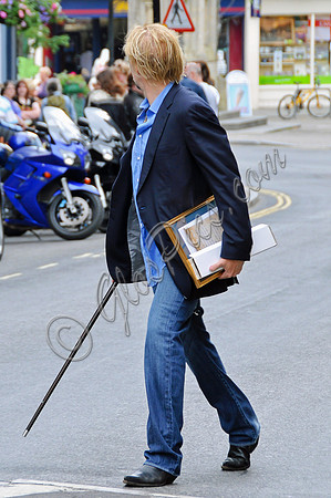 Blonde and bearded, Nicolas Cage with silver tipped walking cane