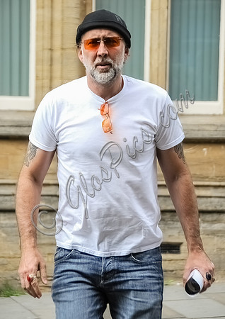 Nicolas Cage wearing beanie hat and orange glasses