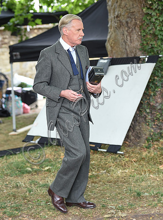 David Robb carrying bottle of Laurent Perrier champagne as he leaves set
