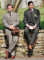 Allen Leech and Rob James-Collier in period dress, sat on Cotswold wall