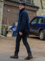 Benedict Cumberbatch wearing denim shirt, flat cap and glasses
