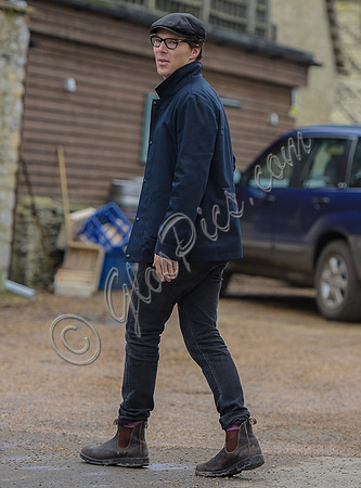 Benedict Cumberbatch wearing denim shirt, flat cap and glasses
