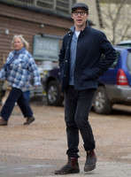 Benedict Cumberbatch wearing denim shirt, flat cap and glasses