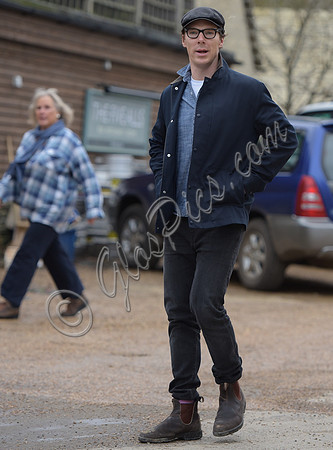 Benedict Cumberbatch wearing denim shirt, flat cap and glasses