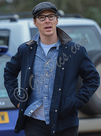 Benedict Cumberbatch wearing denim shirt, flat cap and glasses