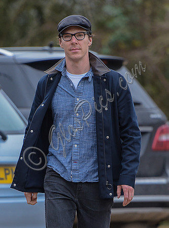 Benedict Cumberbatch wearing denim shirt, flat cap and glasses