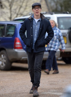 Benedict Cumberbatch wearing denim shirt, flat cap and glasses