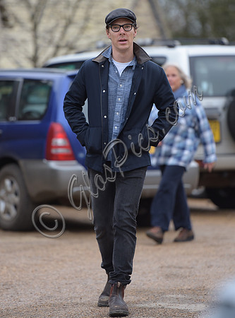 Benedict Cumberbatch wearing denim shirt, flat cap and glasses