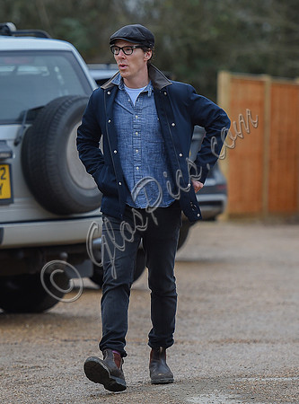 Benedict Cumberbatch wearing denim shirt, flat cap and glasses