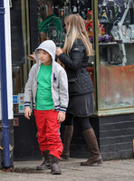 Kal-El Coppola Cage leaving jewellery shop with middle aged woman in Glastonbury, he is wearing Ralph Lauren hoodie, green T shirt, red trousers and heavy work style boots