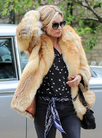 Kate Moss models for camera in fur coat and sunglasses on visit to, Cotswold pub, in Filkins, Oxfordshire