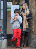Kal-El Cage Coppola leaving café drinking through a straw from a polystyrene cup with middle aged female companion