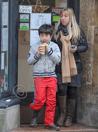 Kal-El Cage Coppola leaving café drinking through a straw from a polystyrene cup with middle aged female companion