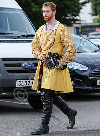 Damian Lewis dressed as King Henry VIII walking right to left (cars in background)