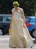 Claire Foy arriving only partly dressed with head lowered and hair in a net.